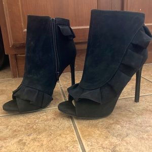 Black peep toe ruffled booties with stiletto heel and zip sides
